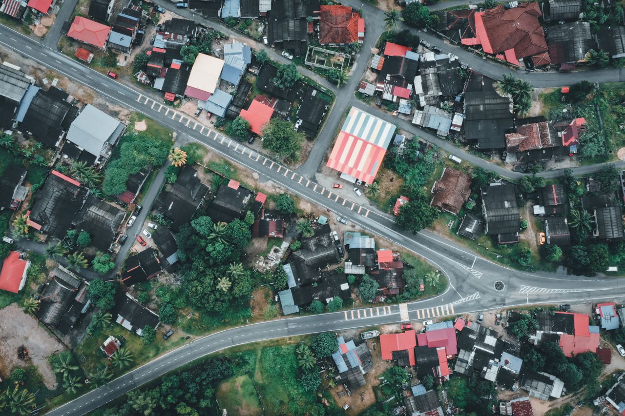 hero-homepage High-angle shot of residential architecture in Chukai, Terengganu, Malaysia, showcasing vibrant rooftops and lush greenery.