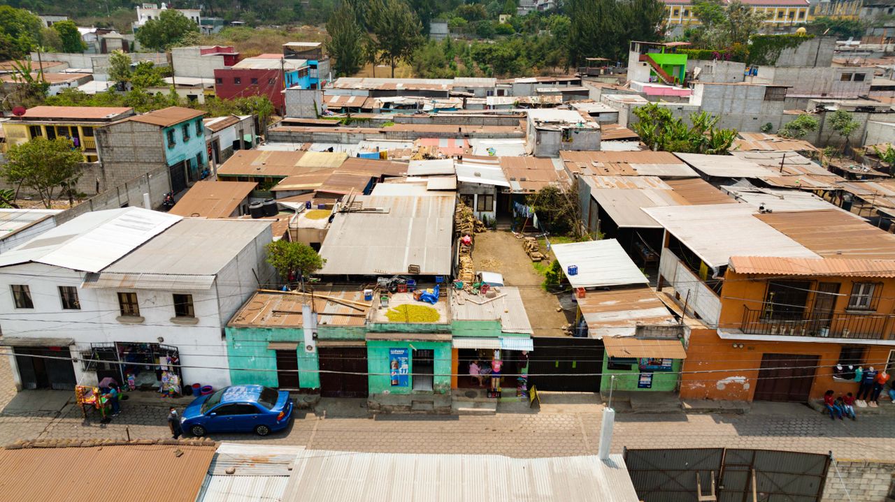 services-03 Aerial view of a diverse urban neighborhood with flat-roofed buildings and street life.