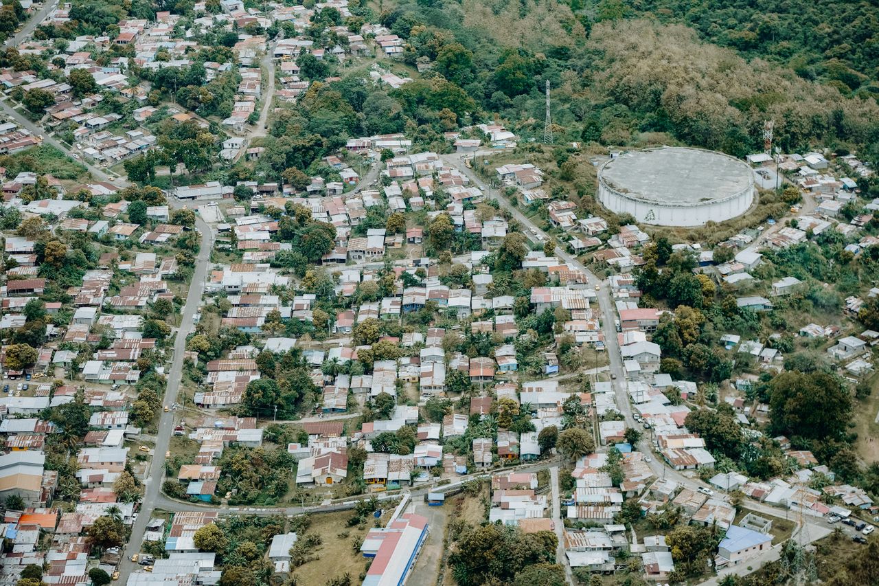 about-01 Aerial view of a suburban neighborhood alongside a large reservoir and lush greenery.