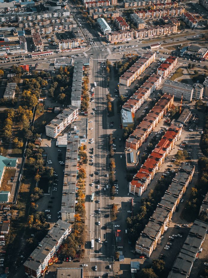 about-02 A stunning aerial view of an urban cityscape featuring residential buildings and busy roads.